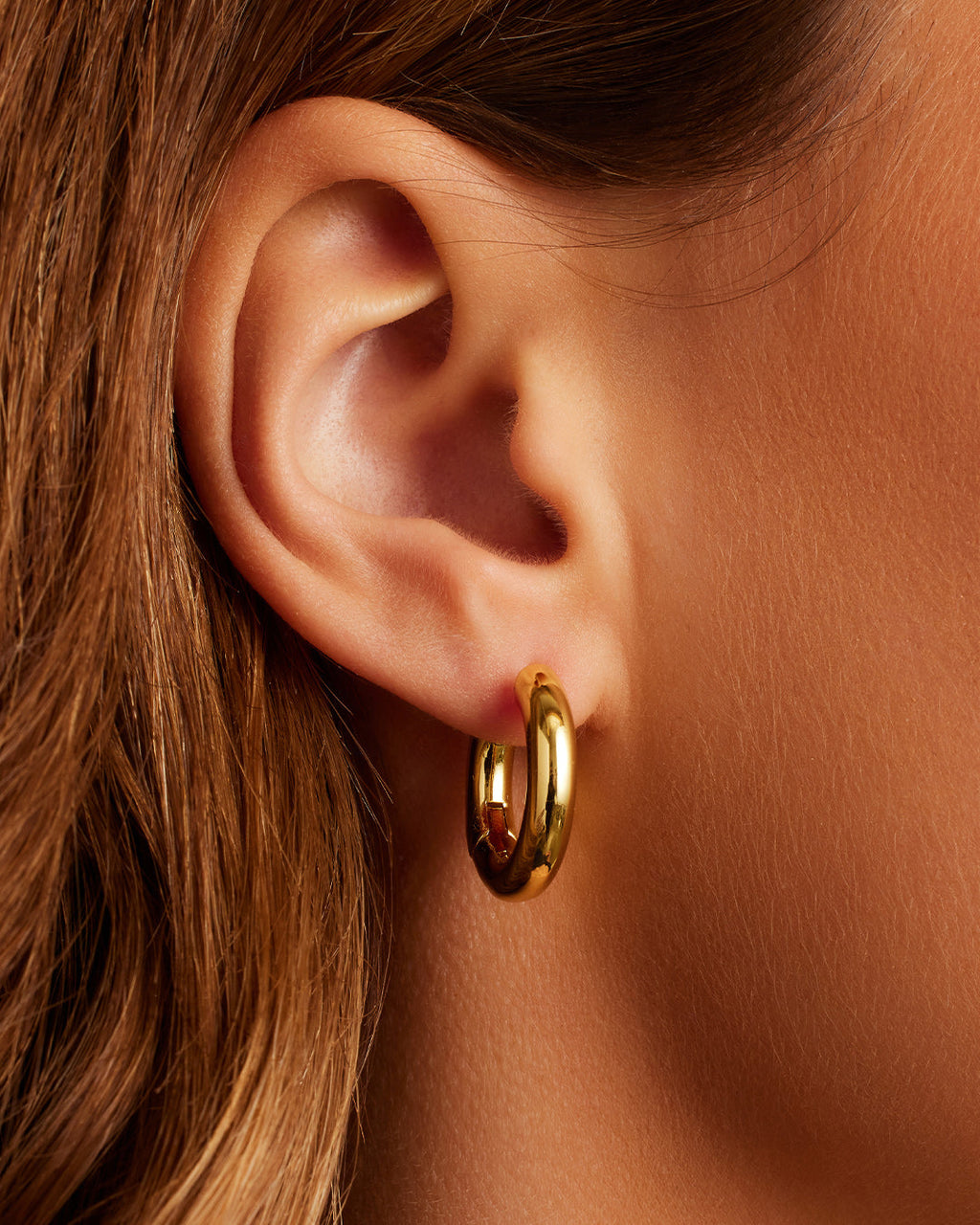 On model Lou Hoops chunky hoops bold hoop earrings || option::18K Gold Plated