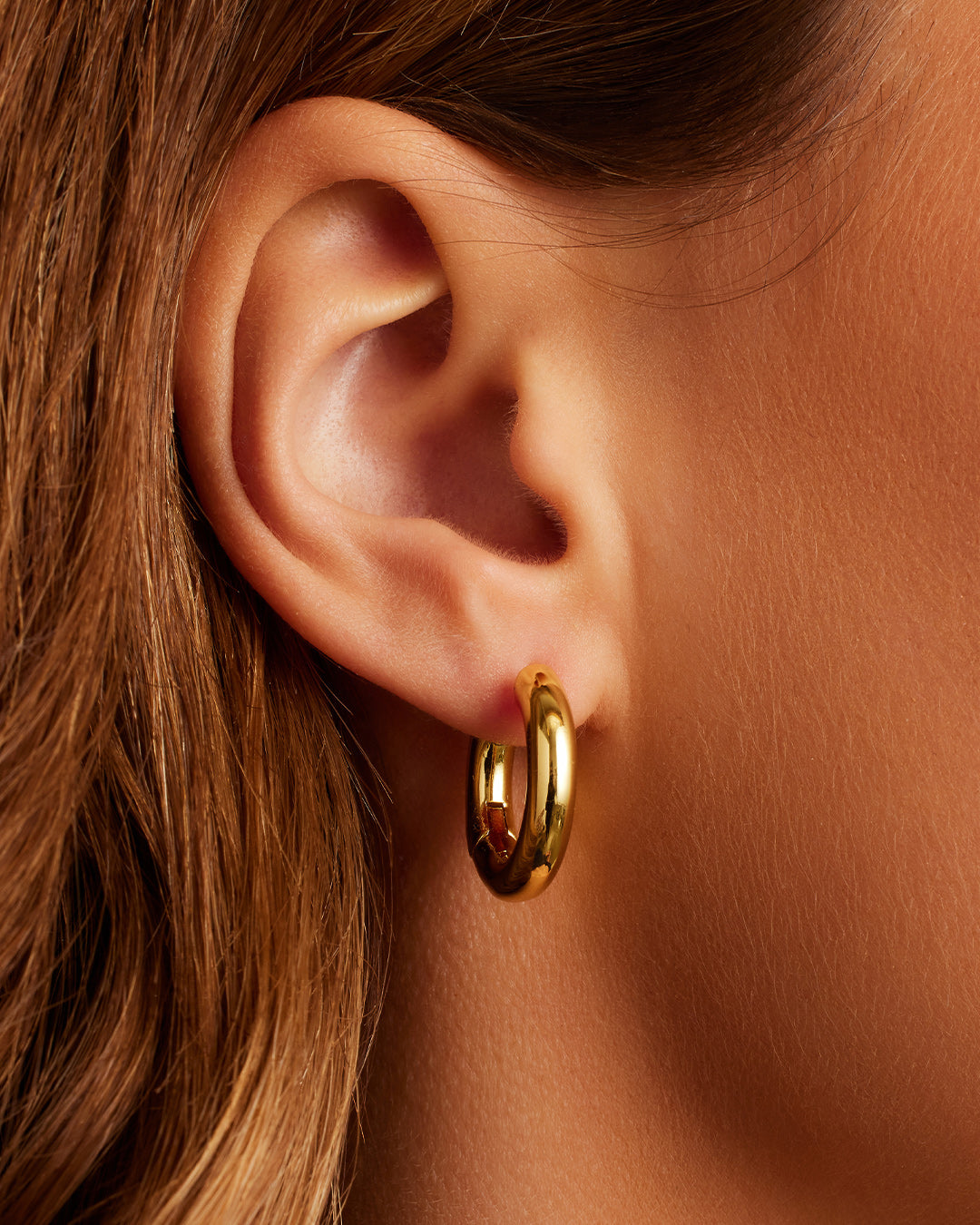 On model Lou Hoops chunky hoops bold hoop earrings || option::18K Gold Plated
